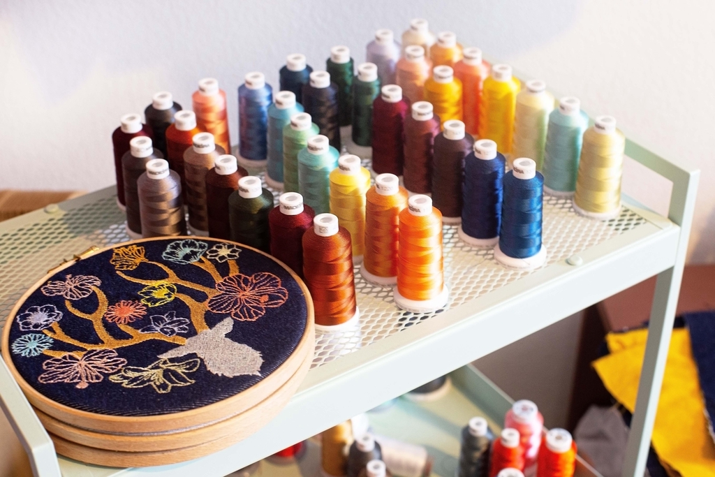 Atelier de broderie artisanale à Mérignac près de Bordeaux avec bobines de fils colorés et création brodée