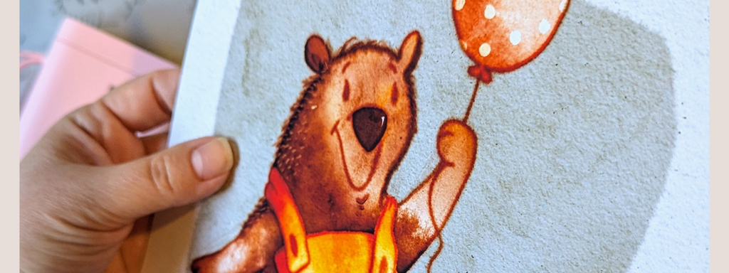 Bear holding balloon