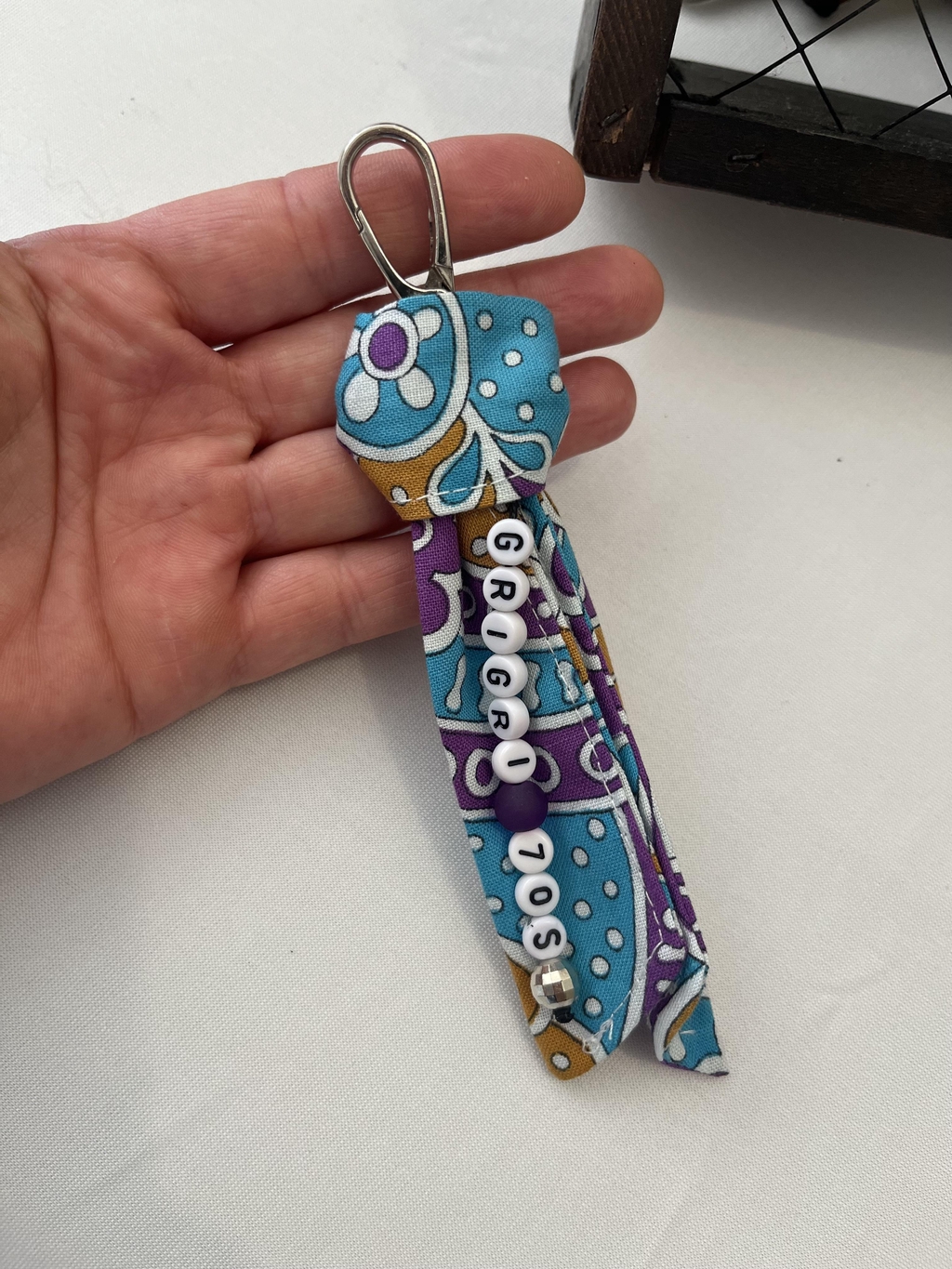 Un petit porte-bonheur chargé d’histoire 

Chaque pièce est réalisée à partir de tissus authentiques des années 70, réinventés pour donner vie à ces gris-gris uniques.