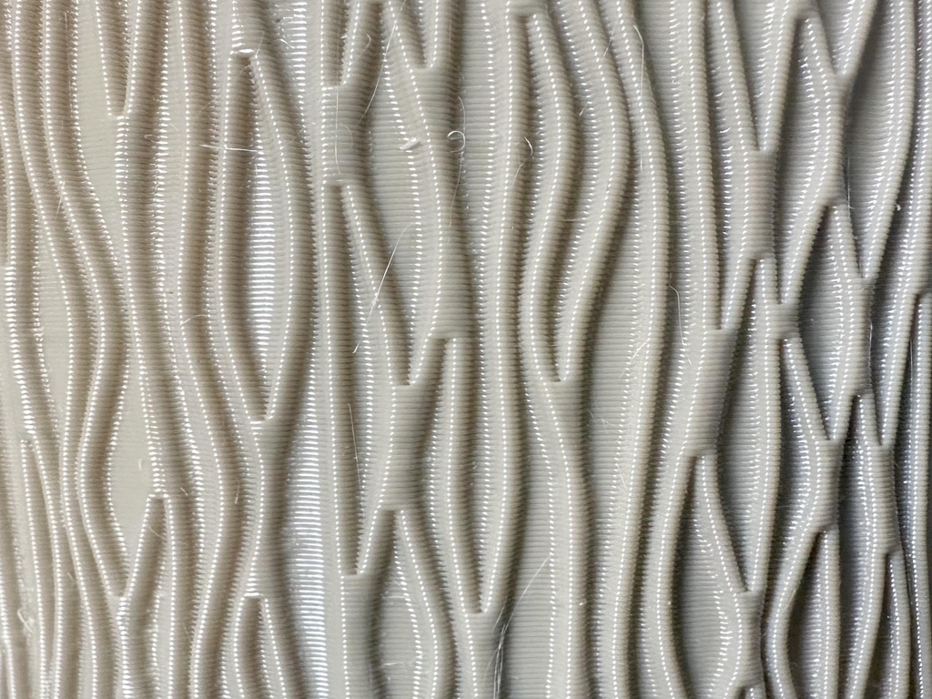 Gros plan sur les lignes d'un cache pot imprimé en 3D, texture ondulée en matière revalorisée.