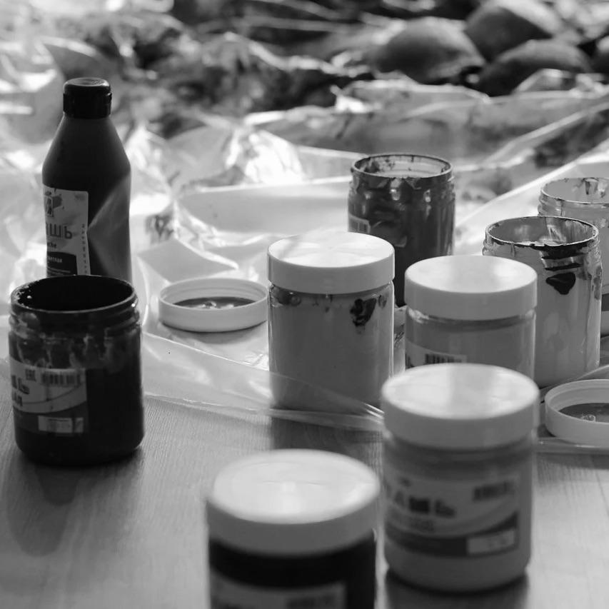 Photo en noir et blanc montrant des pots de peinture et du matériel de sérigraphie, mettant en avant l'artisanat et le savoir-faire local. Cette image reflète le processus de création unique de Vestimentari, où chaque t-shirt, pull et casquette est sérigraphié à la main à Arles. Fidèle à ses racines provençales, Vestimentari allie tradition et modernité en proposant des pièces minimalistes et intemporelles, fabriquées avec soin et passion. Ce souci du détail garantit des produits de qualité, conçus pour un usage quotidien et inspirés par l'authenticité et l'élégance de la Provence.