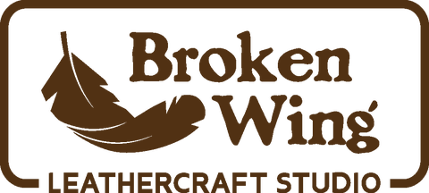 The header banner shows the rectangular "Broken Wing Leathercraft Studio" logo in the centre in a dark earthy brown on a hessian brown background. 
On the left hand side there are three text buttons labeled "Home", "Products", and "About Us".
On the right there is a magnifying glass icon, and a shopping basket icon.
