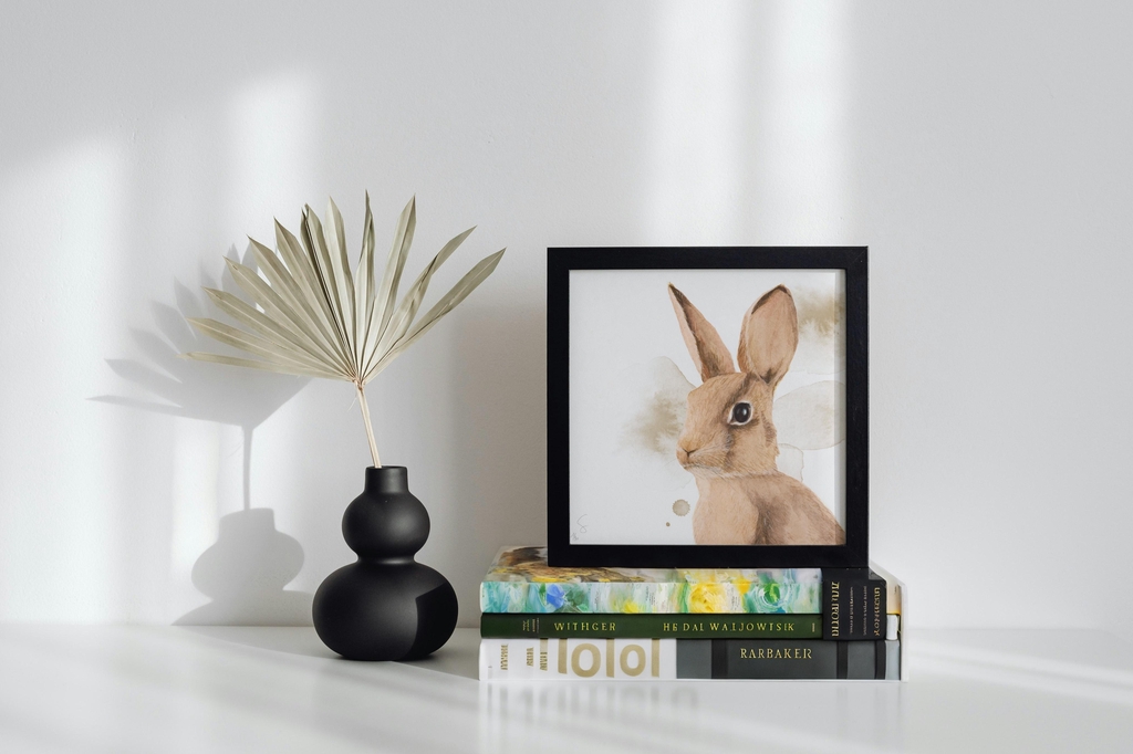 La tirage d'art "Lapin" encadré sur une pile de livre