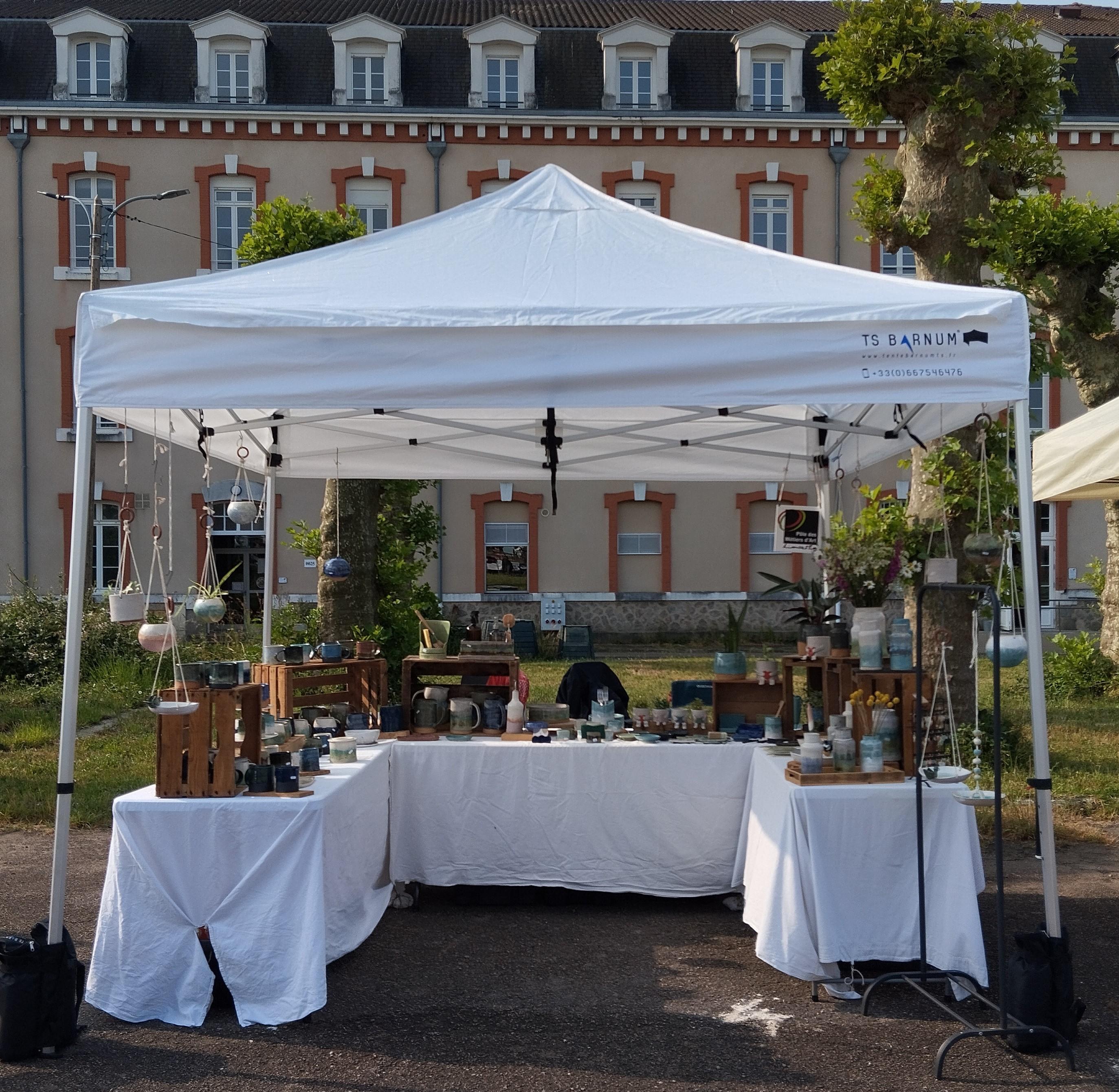 Stand d'exposition de NB Poteries présentant des céramiques artisanales en grès sur un marché local en Haute-Vienne
