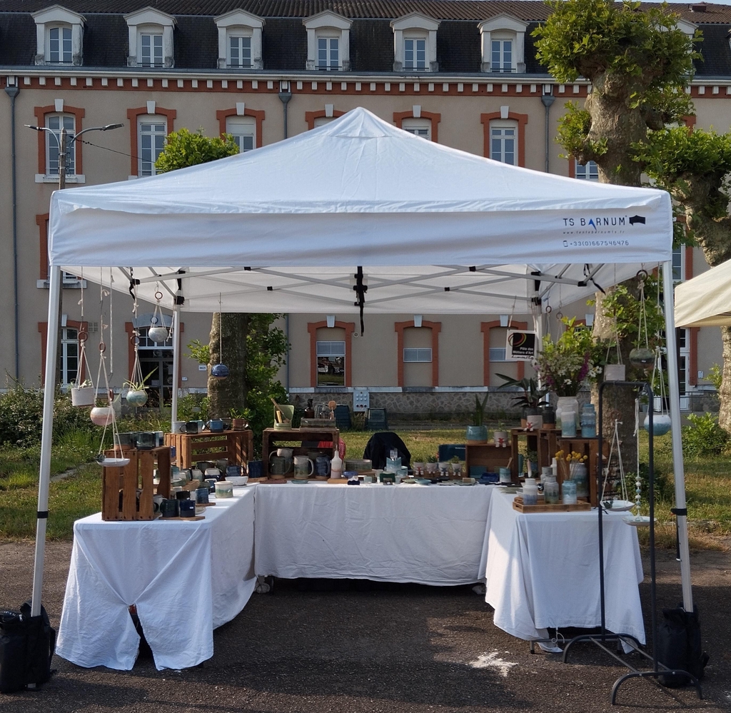 Stand d'exposition de NB Poteries présentant des céramiques artisanales en grès sur un marché local en Haute-Vienne