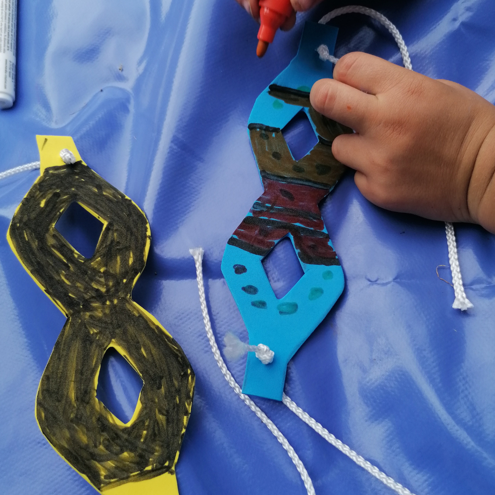 un enfant fabrique son masque de héro. Parfois cela aide à libérer la parole.