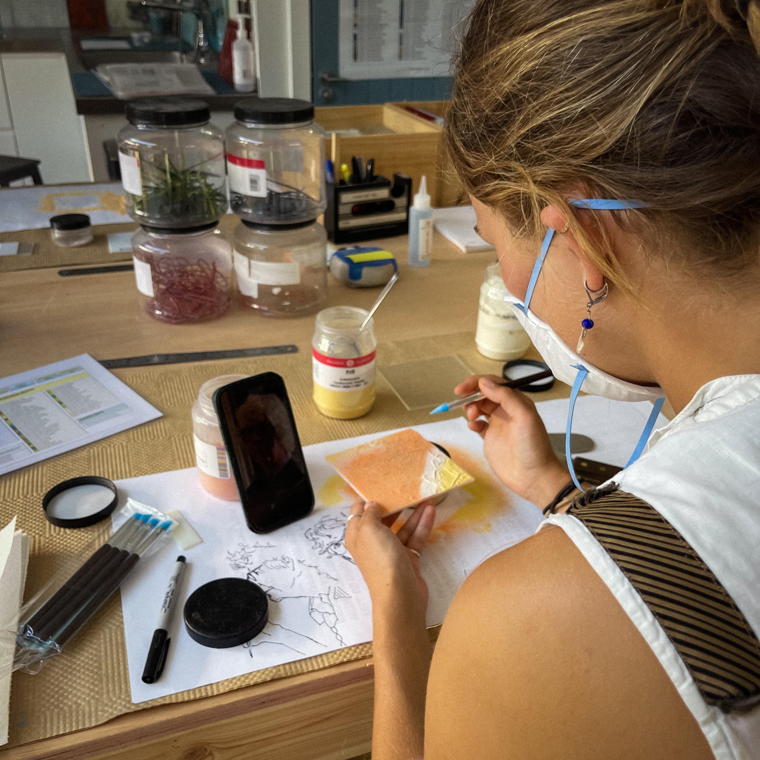 Person decorating glass with a brush