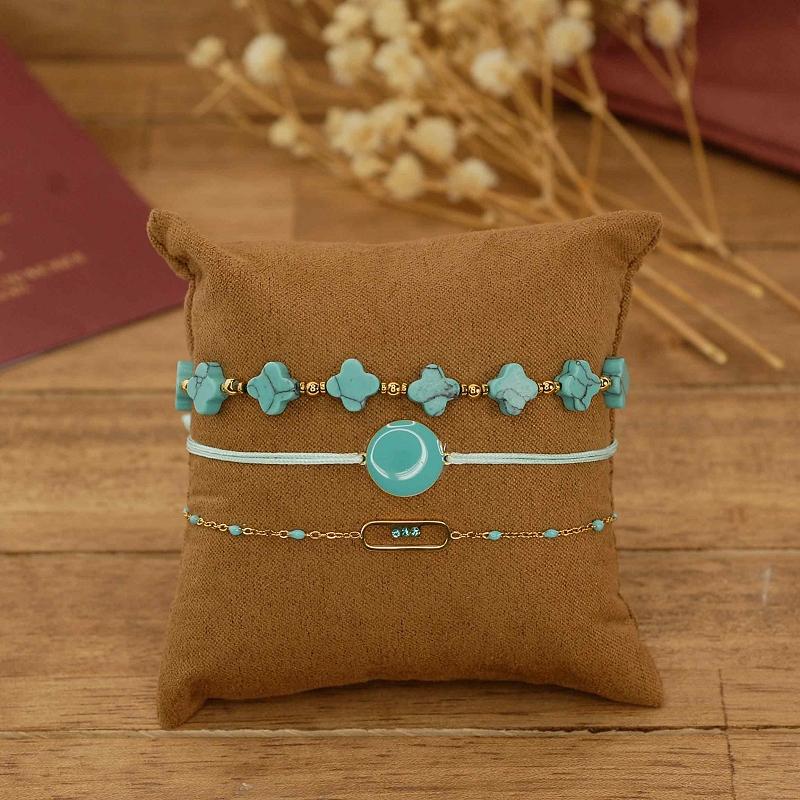 Bracelets fantaisie turquoise et dorés sur présentoir en tissu – bijoux colorés
