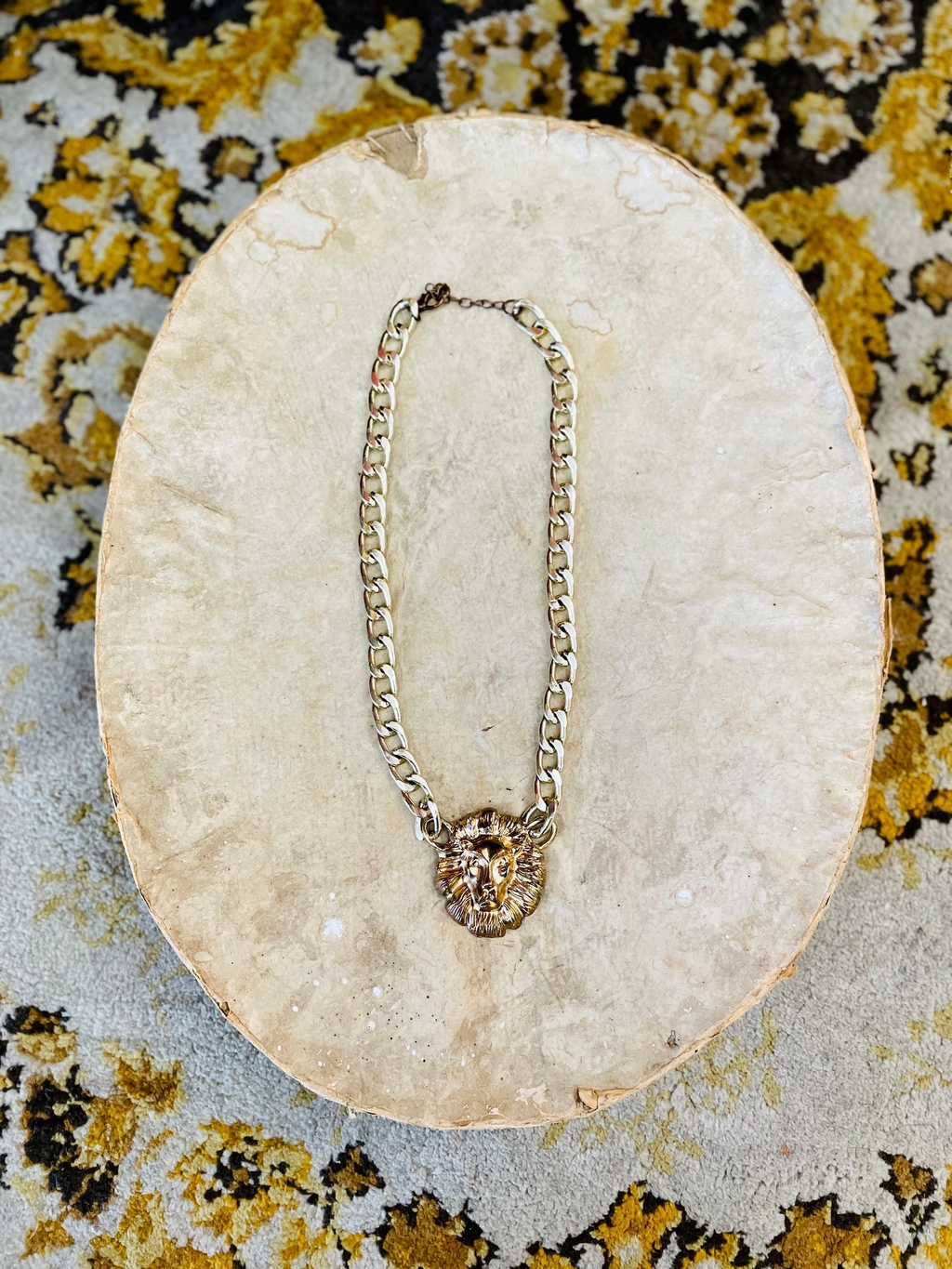 Um colar dourado com um leão.