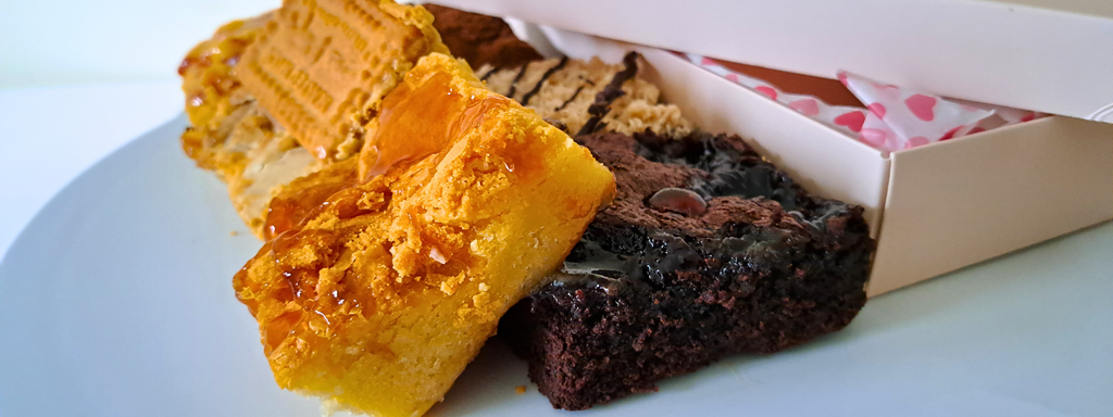Plate of decadent brownies next to a pink box