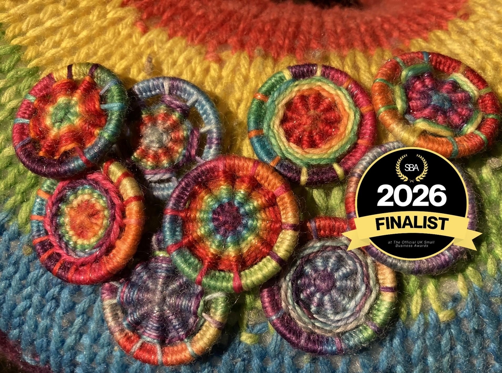 Rainbow Dorset Buttons on a rainbow knitted back ground 