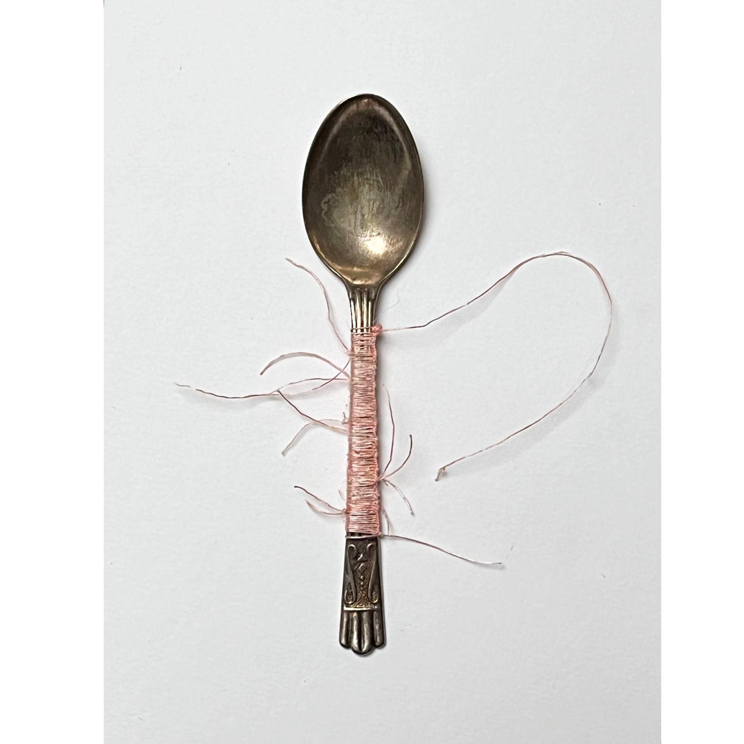 My Mother's Spoon | Textile inspired wall sculpture | Image shows a metal teaspoon with pink thread weaved around the handle.
