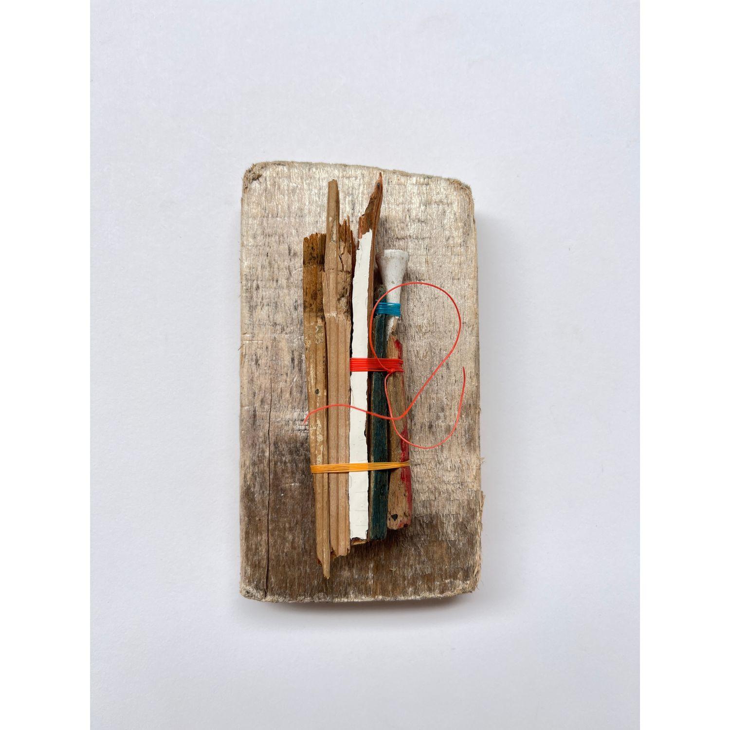 Five | Recycled eco-friendly  wall sculpture.  
Image shows a rectangle of weathered wood with five small splintered of wood attached to it with yellow, orange and blue thread binding.
