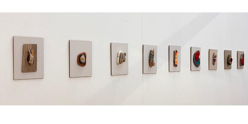 Jane Wood | Sculpture and Assemblage | image show a range of small art pieces made from found objects on a white wall.