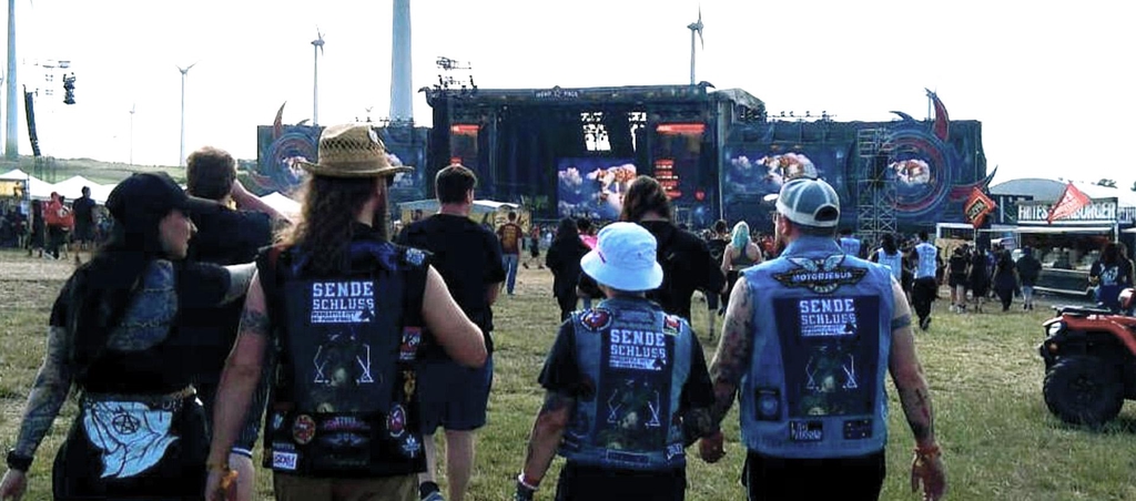 Eine Gruppe von vier Personen auf dem Nova Rock Festival. Drei von vier Personen tragen einen SENDESCHLUSS Backpatch auf der Kutte.