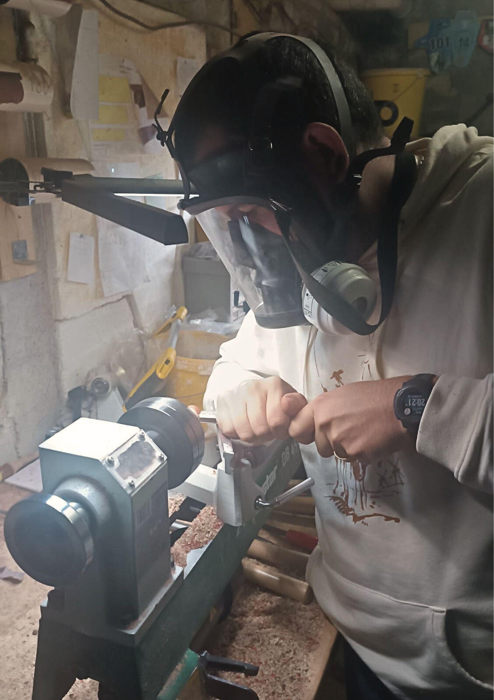 Artisan tourneur de Je 2 Sèves en plein travail de façonnage au tour à bois pour la création de bijoux artisanaux et naturels.