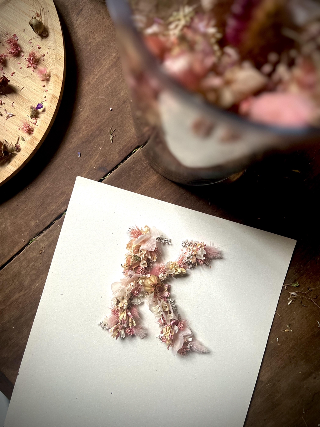 une lettre florale de la collection a fleur de l'être avec des fleurs séchées rose clair