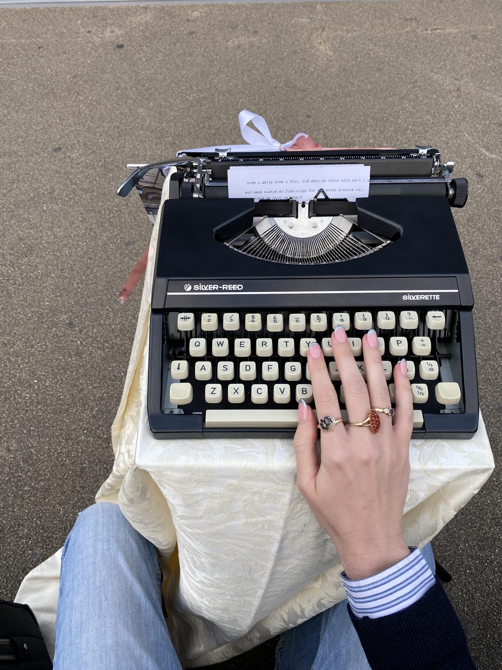 typewriter with a woman's hand resting on the keys