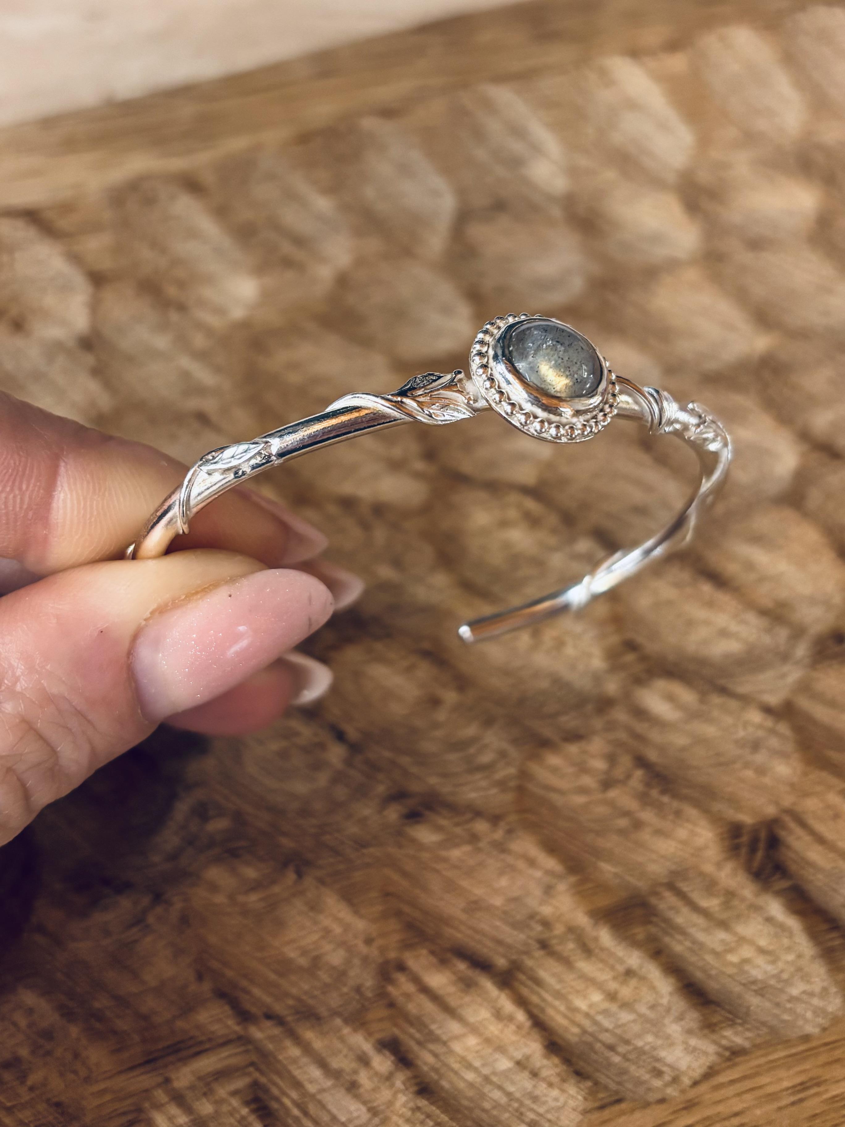 Manchette en argent qui est entrelacée de feuillage avec une Labradorite au centre