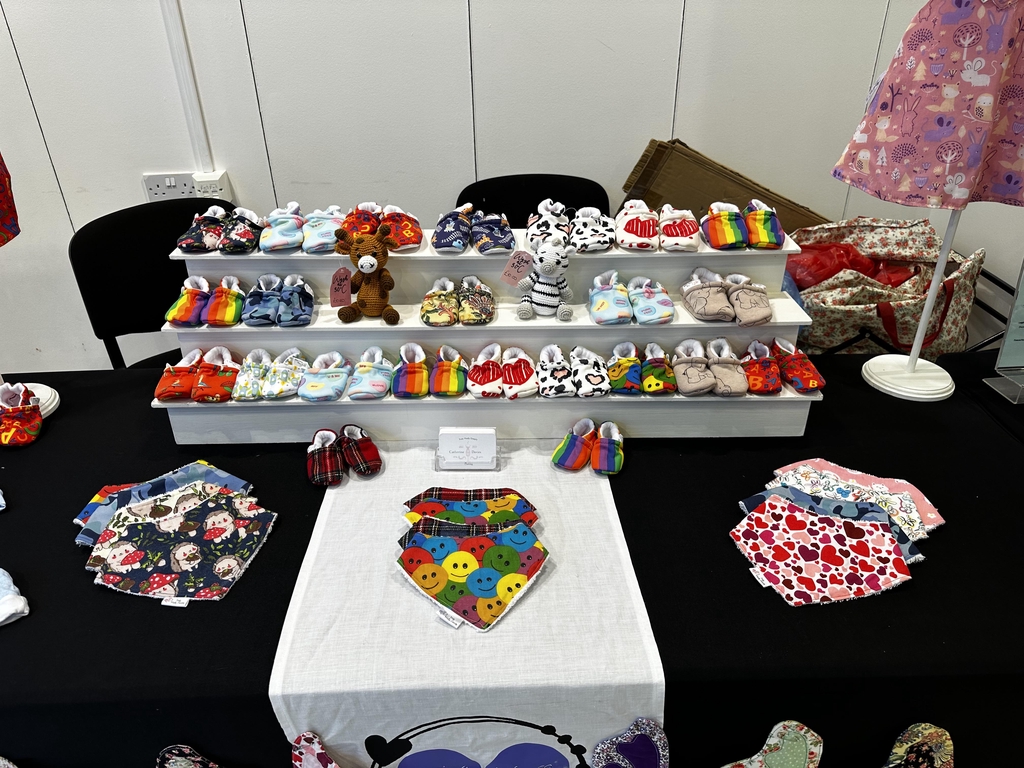 I hand make baby and children's clothes and accessories. Dresses and dungarees out of cotton-based fabrics and matching accessories for example slippers and bibs; Two piece sets out of cotton jersey; Fleece jumpers and sweatshirts hoodies. I make sizes from newborn to three years old to show and sell off the peg but can make to order up to teenagers or even adult sizes in some cases.