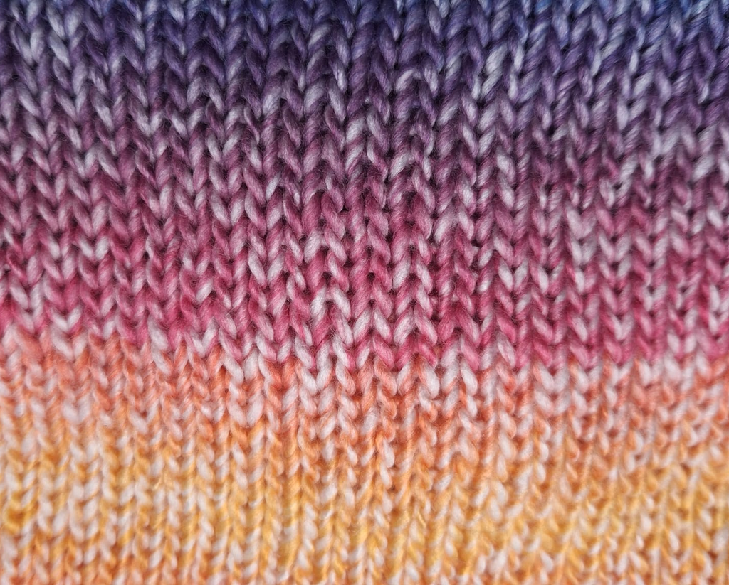 De banner toont een breimotiefje in regenboog kleur