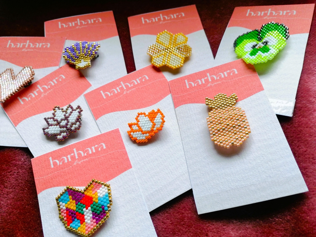 Séries de broches diverses formes (fleurs, cœurs, ananas) et couleurs vives.