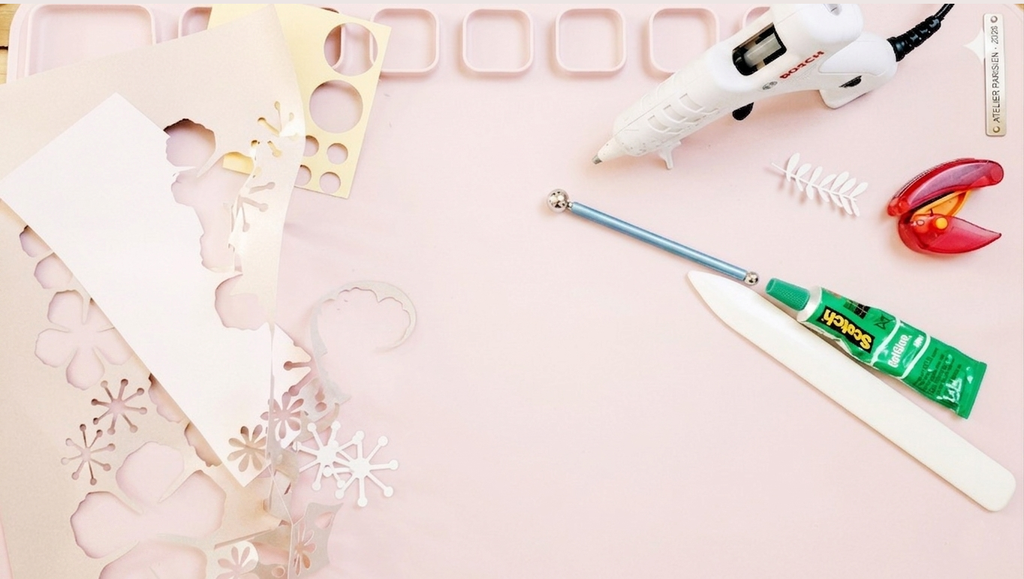Atelier papier découpé des ciseaux et un pistolet a colle sont poses sur une table