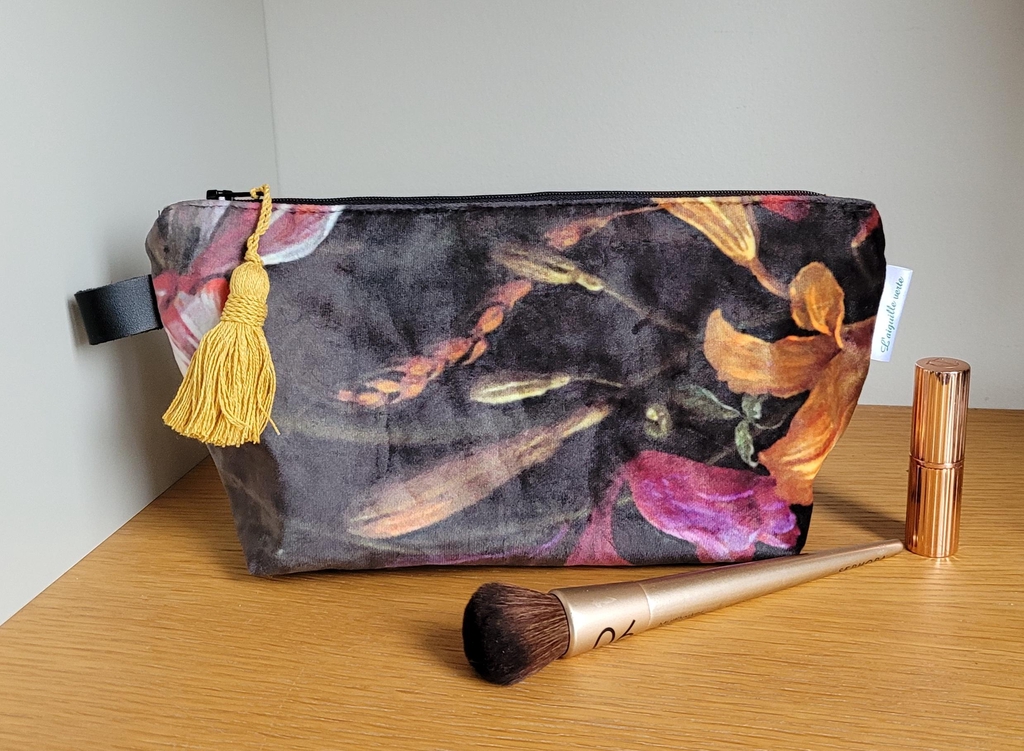 Trousse de maqillage boudoir aux motifs végétals de couleur sur fond velours noir
