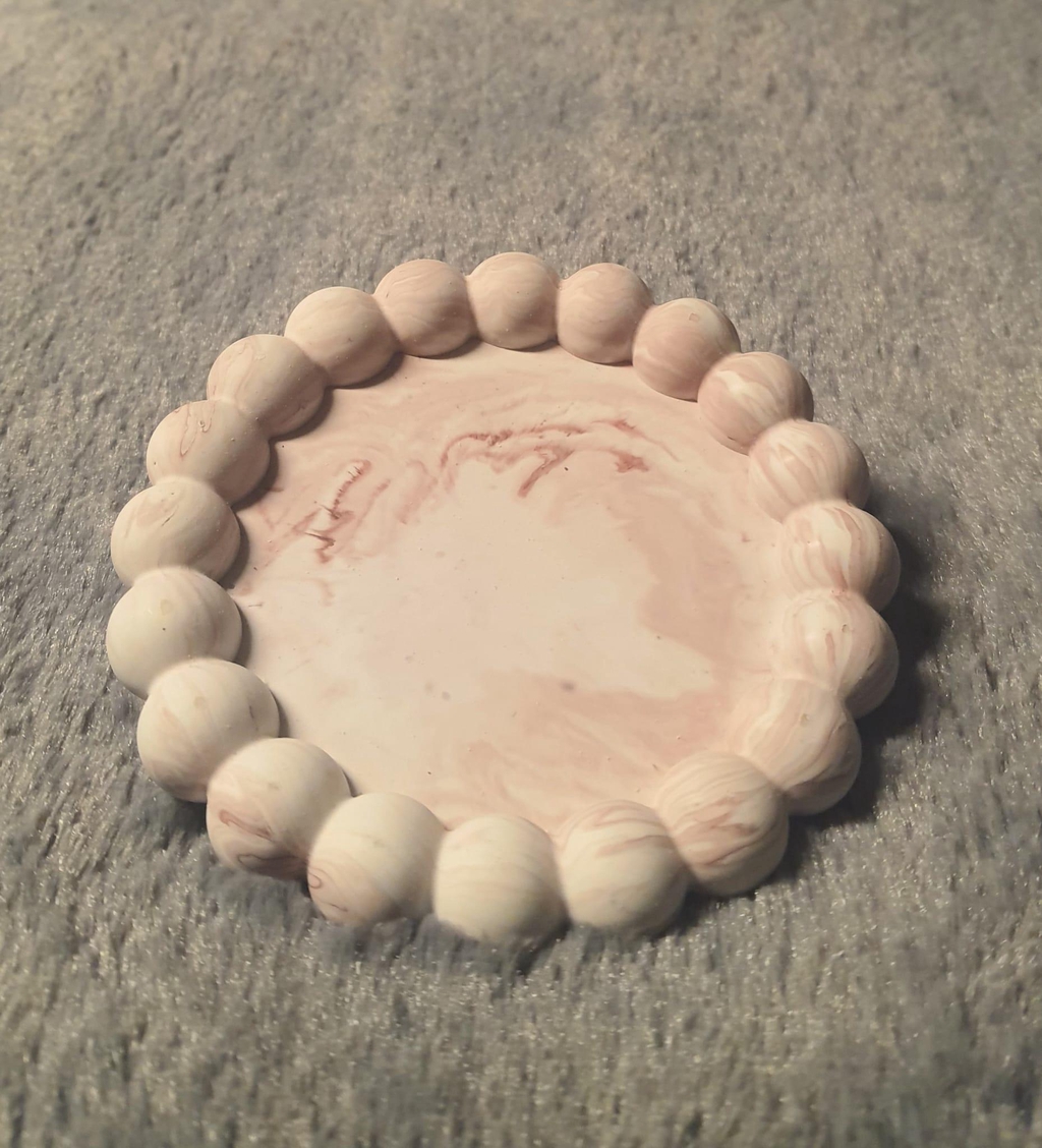 un plateau bulle de forme ronde, de couleur effet marbré marron rosé et blanc, coulée en jesmonite