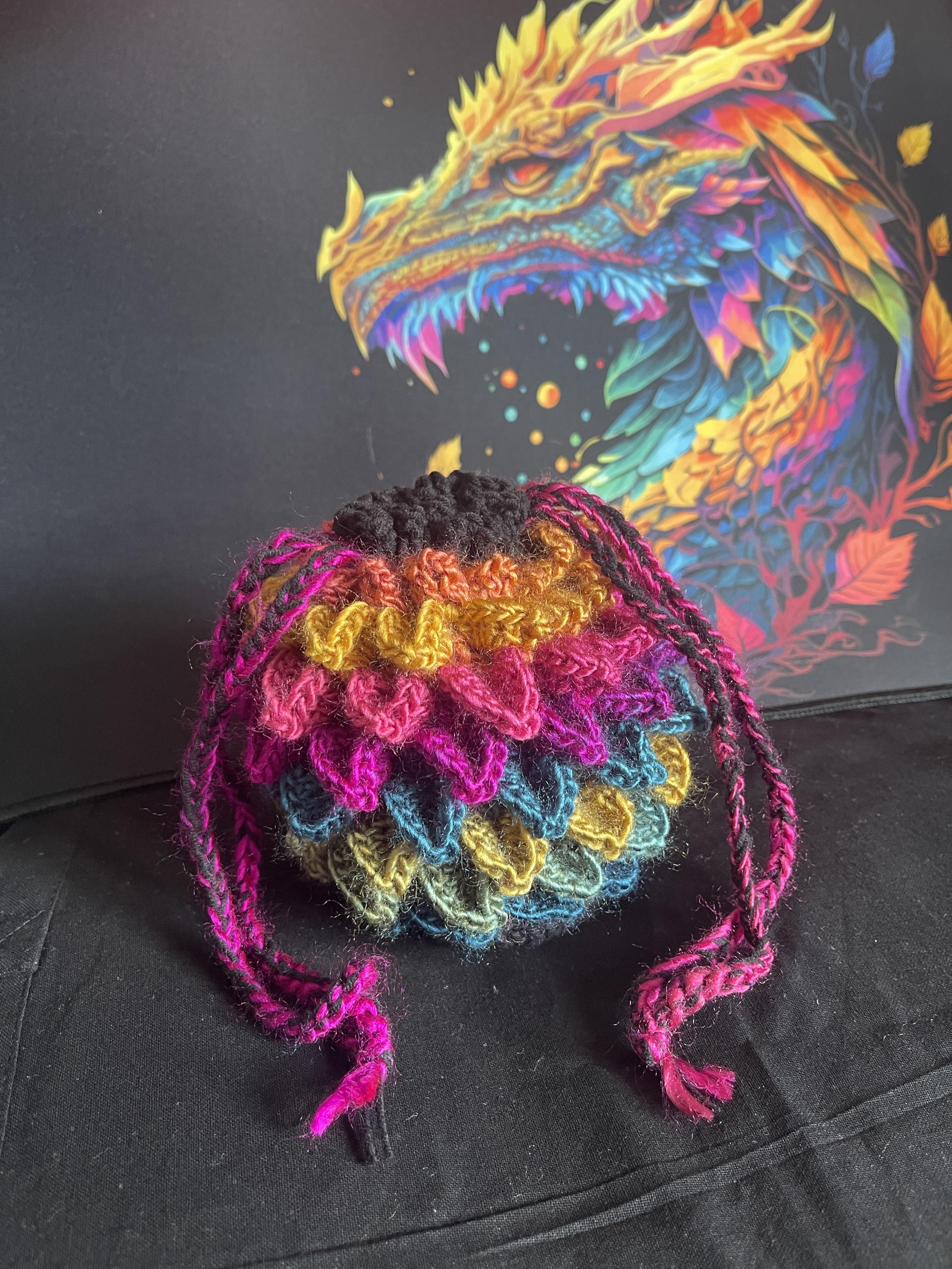 Collection of small handmade crochet drawstring bags in various colours and textures, suitable for storing dice, crystals, charms, or keepsakes.