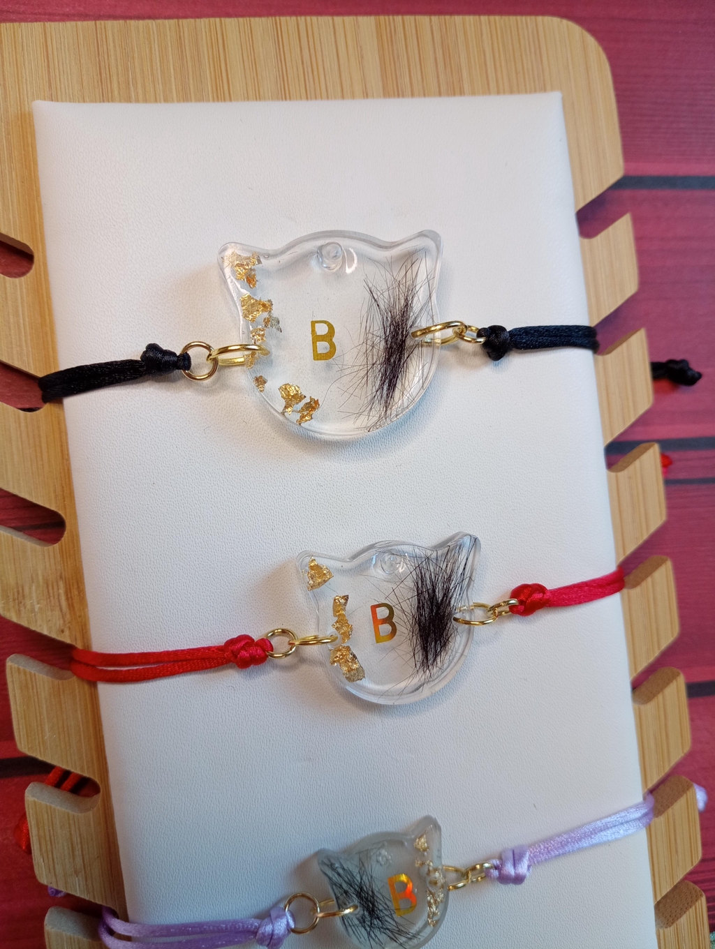 Bracelet souvenir en résine avec poils de chat et véritables feuilles d’or, réalisé à la main. Monté sur un cordon réglable, ce bijou unique vous permet de garder votre compagnon près de vous avec élégance et émotion.