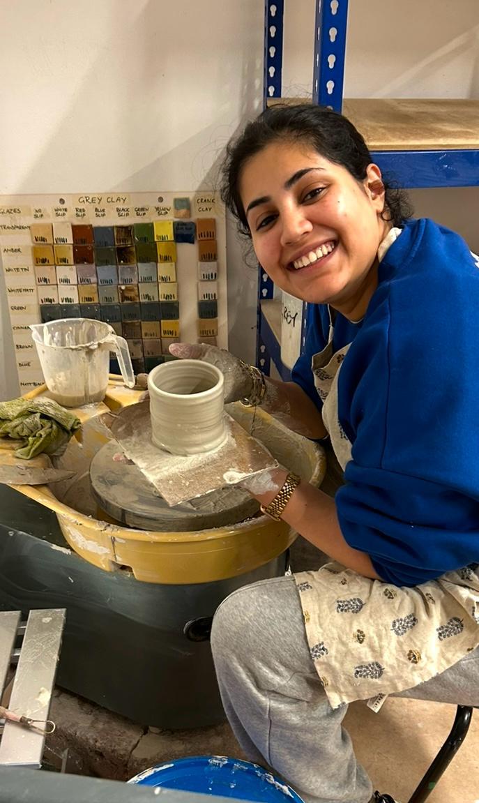 pottery student working on the wheel