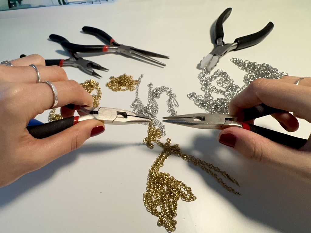 Bijoux faits main en acier inoxydable doré et argenté, réalisés en atelier avec assemblage de chaînes et apprêts. Création de bijoux sur mesure pour femmes et hommes, incluant bagues, boucles d'oreilles, bracelets et colliers.