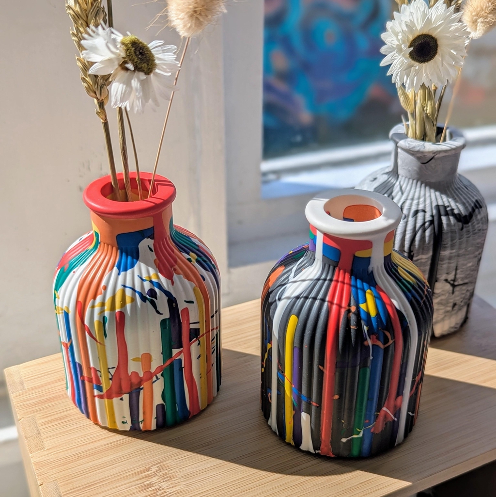 Colourful bud vases holding dried flowers