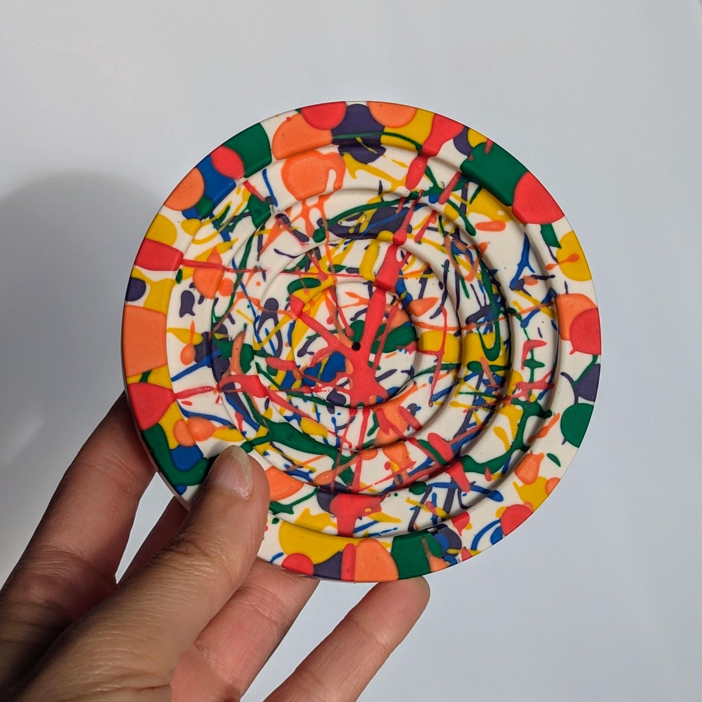 Brightly coloured incense holder in a paint splatter design