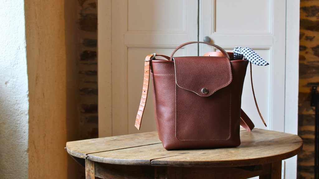 Sac n°4 en cuir chocolat, fait main, modèle unique, posé sur une table en bois, ambiance cosy – création artisanale 31 mai maroquinerie