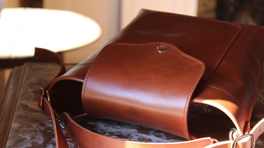 Sac n°4 en cuir acajou, fait main, modèle unique, posé sur une console en bois et marbre, ambiance cosy – création artisanale 31 mai maroquinerie