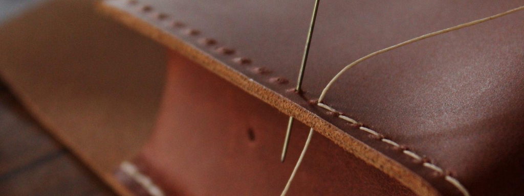 Couture sellier sur cuir marron lors d’un atelier d’initiation au travail du cuir à La Peausserie à Rennes