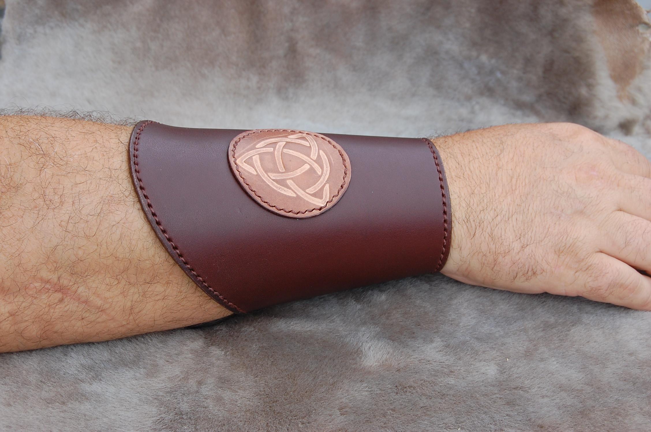 Les canons d’avant-bras en cuir sont des accessoires indispensables pour les passionnés d’univers médiévaux, de reconstitution historique ou de jeux de rôle grandeur nature. Fabriqués à partir de cuir véritable, ces protections d’avant-bras allient solidité, confort et authenticité, tout en offrant un rendu visuel fidèle aux armures d’époque.
Nos canons avant-bras en cuir artisanaux sont confectionnés à la main, selon les techniques traditionnelles de la maroquinerie et de l’artisanat médiéval. Chaque pièce est unique : le cuir épais assure une excellente protection tout en restant souple et agréable à porter. Les lanières réglables permettent un maintien parfait, que ce soit pour un usage en costume médiéval, cosplay, ou LARP (jeu de rôle grandeur nature).
Choisir un canon d’avant-bras en cuir véritable, c’est opter pour un accessoire robuste et esthétique, conçu pour durer. Nos modèles, disponibles pour homme et femme, sont proposés en plusieurs teintes naturelles (marron, noir, cognac) et peuvent être personnalisés selon vos préférences. Le canon avant-bras cuir made in France incarne parfaitement le mariage entre authenticité, savoir-faire et passion de l’histoire.
