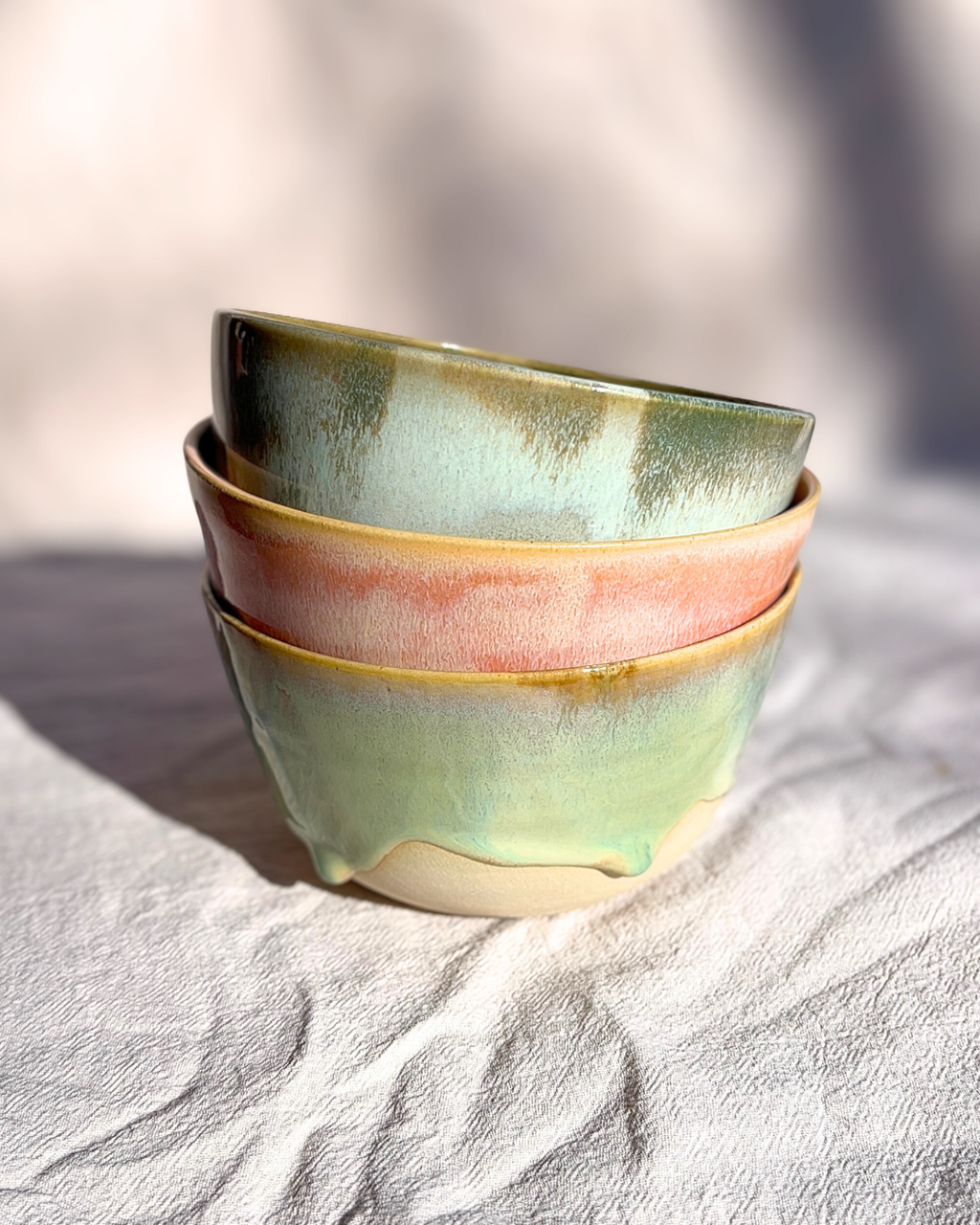 Une sélection de vaisselle artisanale en grès aux émaux nuancés, où chaque bol et chaque tasse dévoile des variations de couleurs uniques inspirées par les paysages naturels.