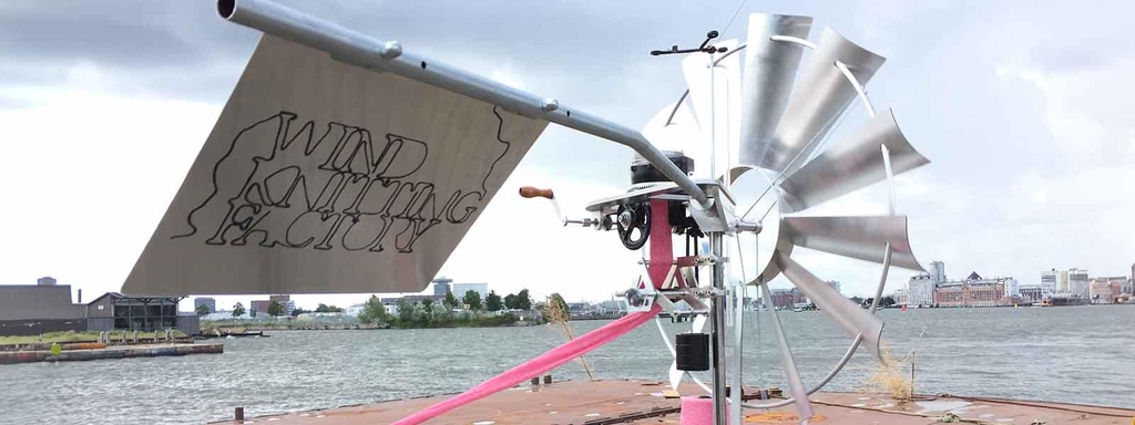 The Wind Knitting Factory at the waterside of the NDSM wharf in Amsterdam. Its knitting a bright pink sustainable fashion scarf with making use of 100% wool, lambswool from the united kingdom with a gots label