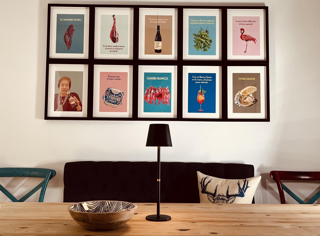 Tienda Online allegra.douglas: Decoración, Pósters, Regalos, Souvenirs, Posavasos de Cultura Española. En esta imagen se ve una mesa de comedor y la decoración de la pared del comedor, compuesta por 10 marcos que muestran los pósteres de allegra.douglas.