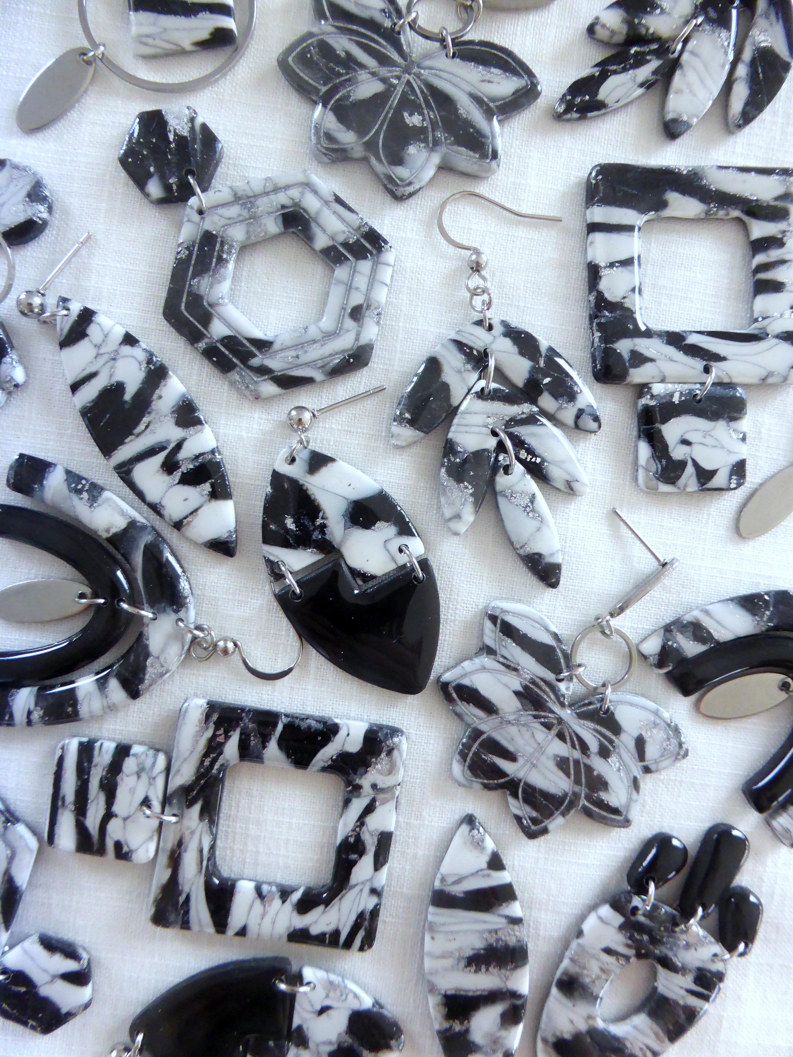 Collection de bijoux en pâte polymère de couleurs noir, blanc et argenté.
