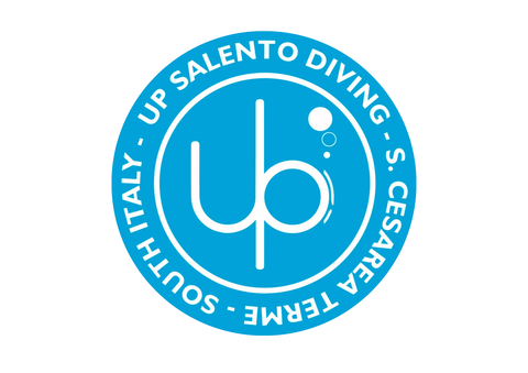 Logo di Up Salento Diving | Shop al centro stilizzati in bianco ci sono una U e una P che vanno a formare la faccia di un subacqueo. Il logo è circolare con sfondo celeste e scritte in bianco.