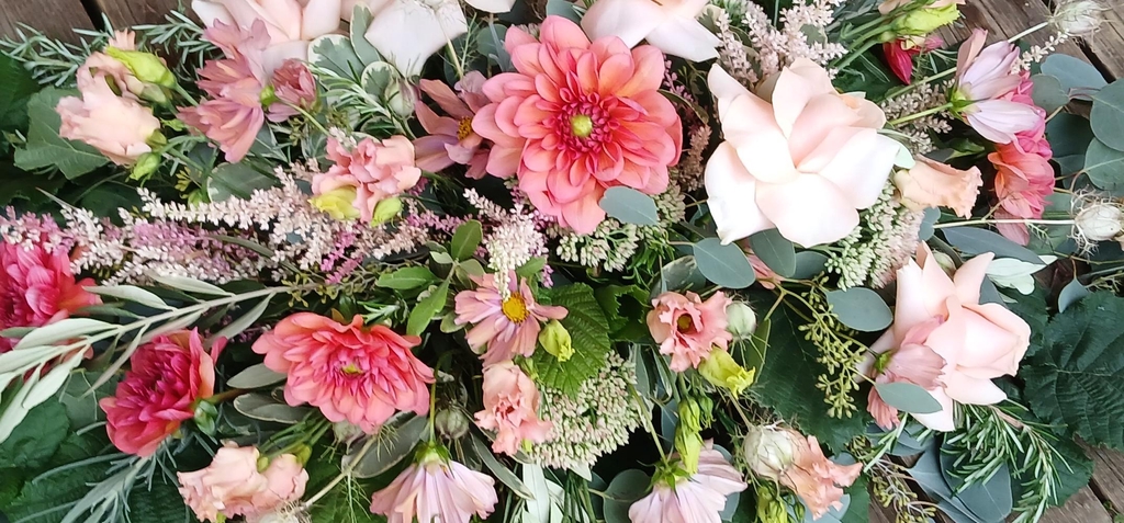 A spray of flowers including blush pink dahlias and lisianthus.